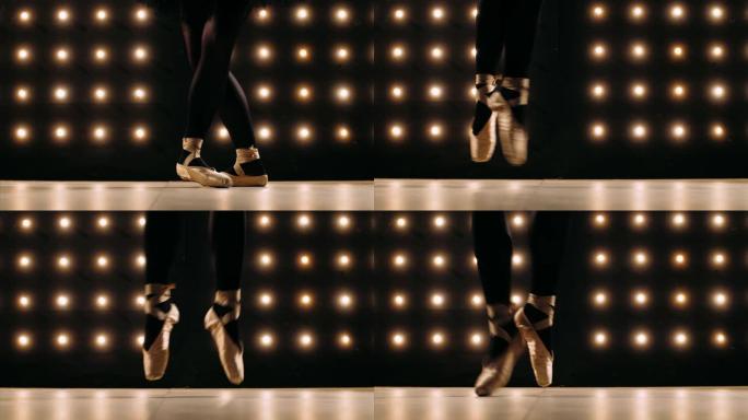 穿着足尖鞋的芭蕾舞女演员的脚在黑暗的工作室里跳芭蕾舞。