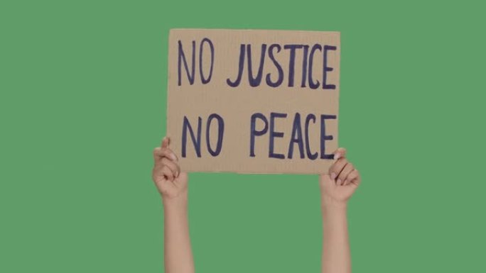 女性的手从纸板箱上拿着海报，上面写着 “没有正义就没有和平”。抗议种族主义和警察暴行。隔离了一个绿色
