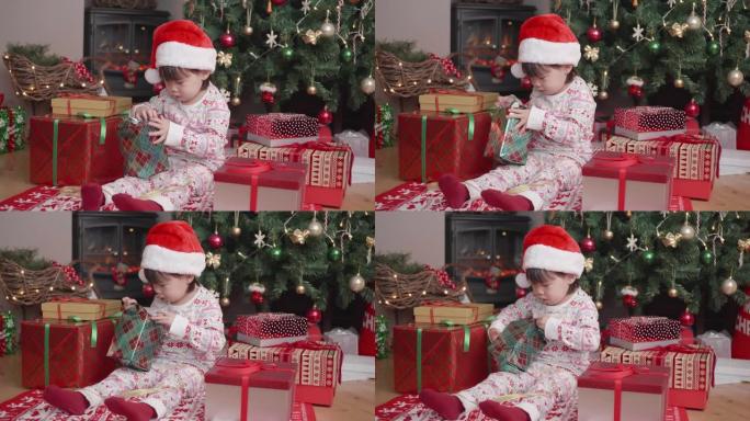 蹒跚学步的女孩在家里的圣诞树旁边打开圣诞礼品盒