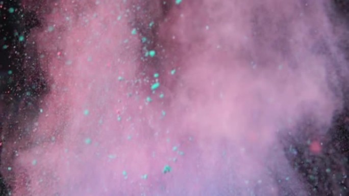 深色孤立背景上彩色五彩粉的超慢动作爆炸。粉末团向上飞，与烟雾混合。