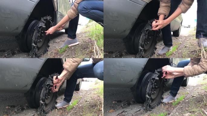 女人正试图解决高速公路上轮胎爆炸的问题