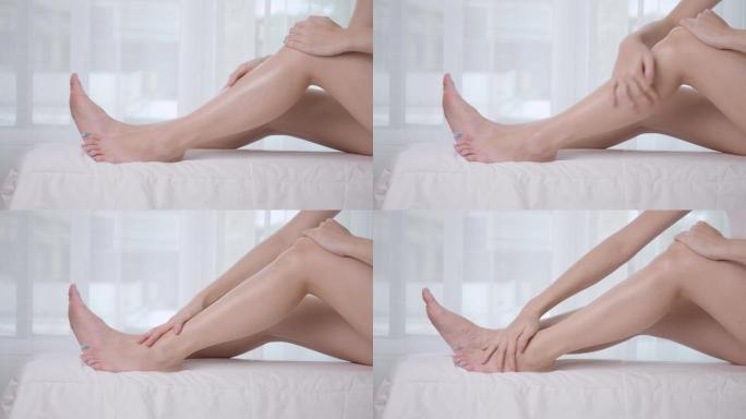 亚洲妇女在家庭工作室使用腿部乳液。白霜擦洗治疗皮肤状况。