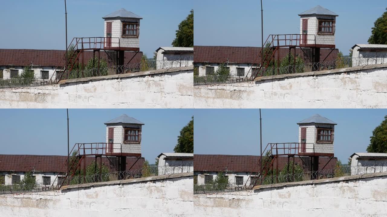 旧监狱。监狱。铁丝网。带金属倒钩栅栏的白色墙壁。