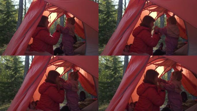 妈妈和小女儿在红色帐篷露营大自然里玩耍