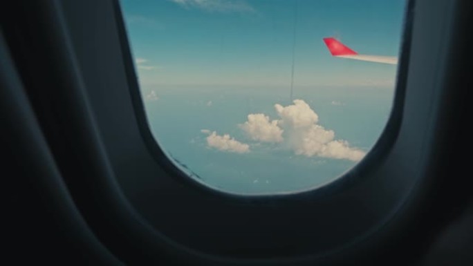 第一人称视角。天空中的飞机。飞机窗户或舷窗外的云。飞机机翼在高处，可以看到云层。