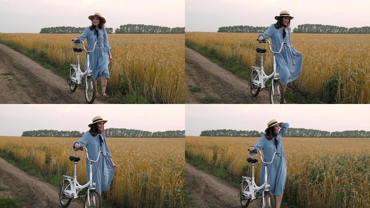 女人骑着自行车沿着乡村道路麦田散步，享受生活和自然。