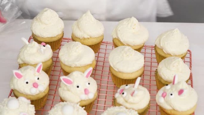 复活节用白色奶油糖霜装饰香草纸杯蛋糕。