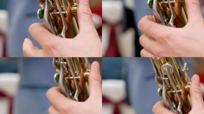 男性手演奏萨克斯管。慢动作和特写
