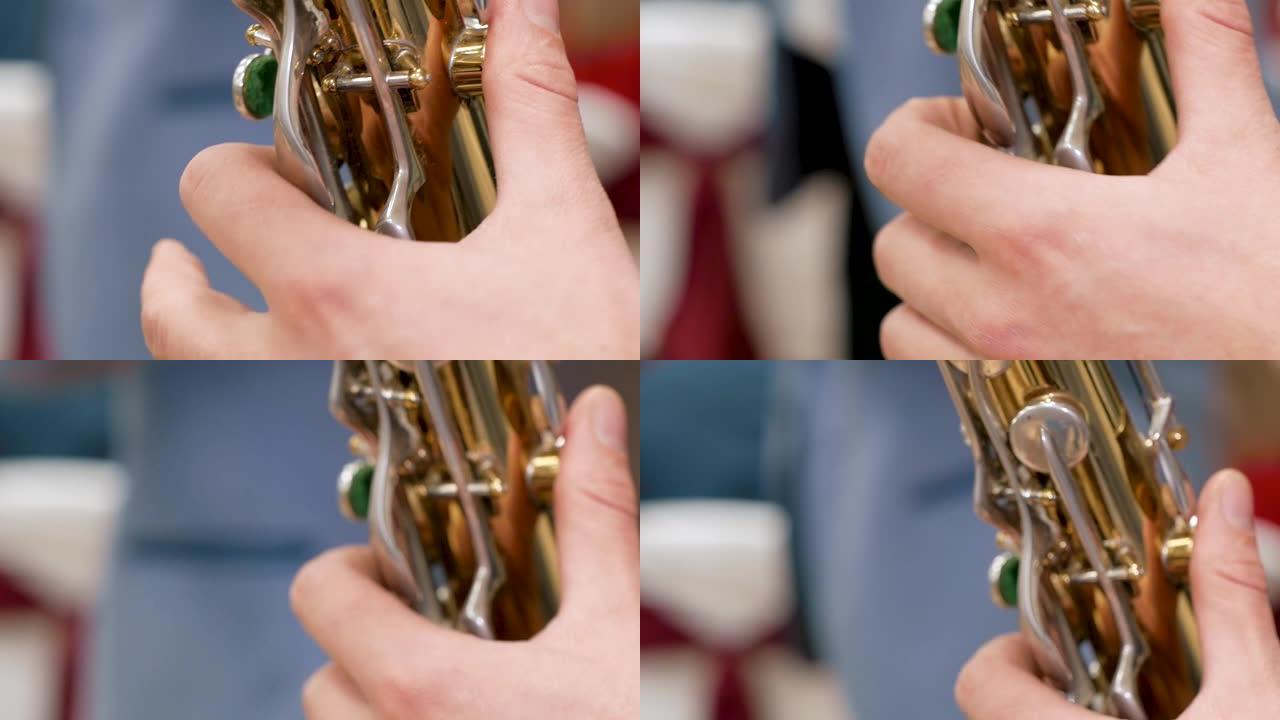 男性手演奏萨克斯管。慢动作和特写