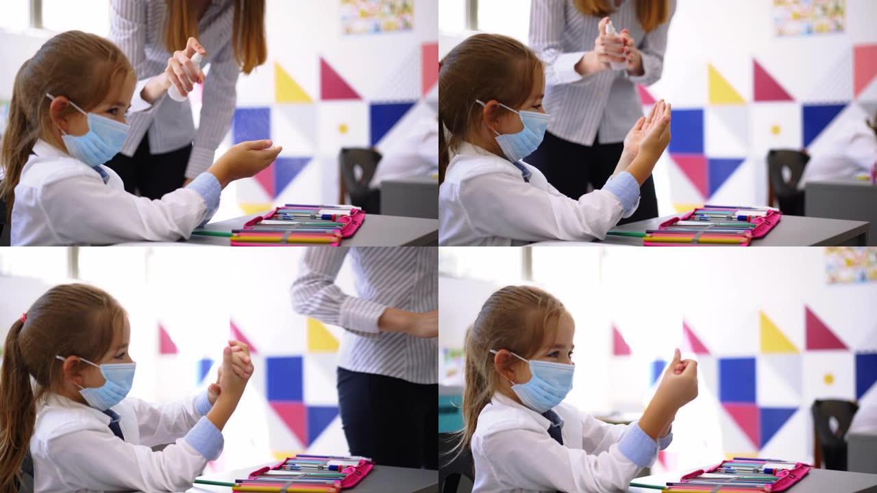 年轻的女教师在教室里给学生的手消毒