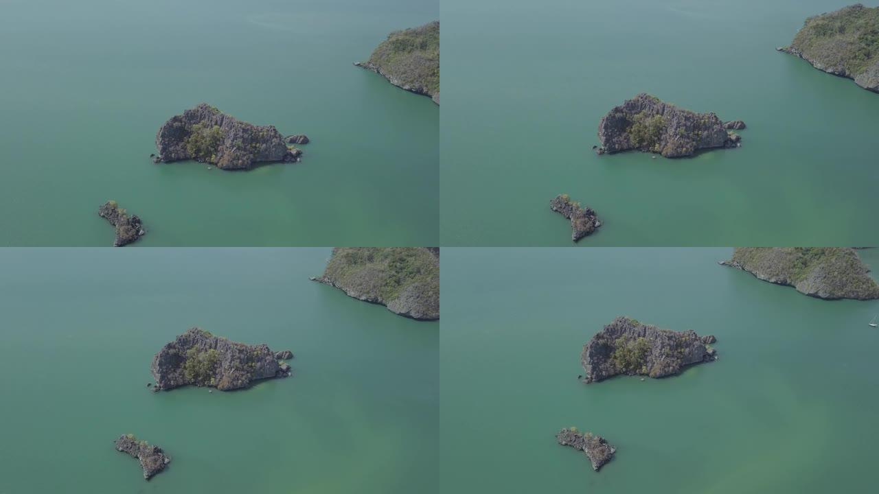 海中岛屿的航拍画面。船漂浮在岛附近。Park Kilim Geforest，兰卡威，马来西亚。无人机
