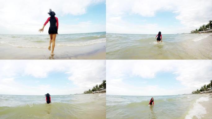 穿着泳装的女孩在泰国华欣的海滩上奔跑。