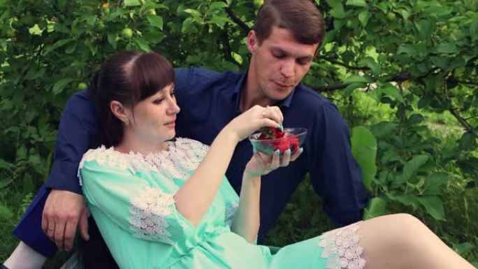 一个女人表现出温柔，用草莓喂男人的特写镜头。