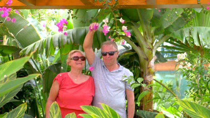 在热带花园中拥抱爱情的高级夫妇4k慢动作60fps