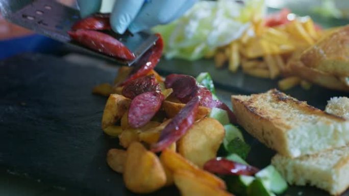 美味的食物，芬芳的炸土豆和狩猎香肠，在餐厅或咖啡馆的厨房为游客准备的黑盘上放吐司片