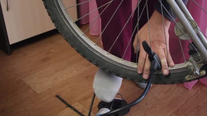 一个人用1英尺泵将空气泵入自行车车轮。特写镜头。