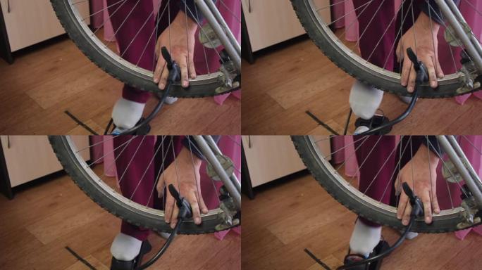 一个人用1英尺泵将空气泵入自行车车轮。特写镜头。