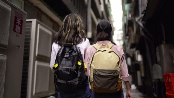 两个女性朋友探索新市镇的狭窄通道。
