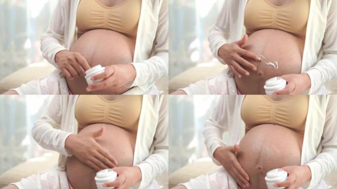 孕妇，她正在在胃部涂抹乳霜，防止皮肤破裂。