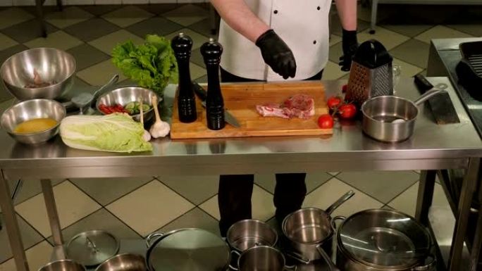 厨师在餐厅的木板上撒上新鲜的胡椒牛排