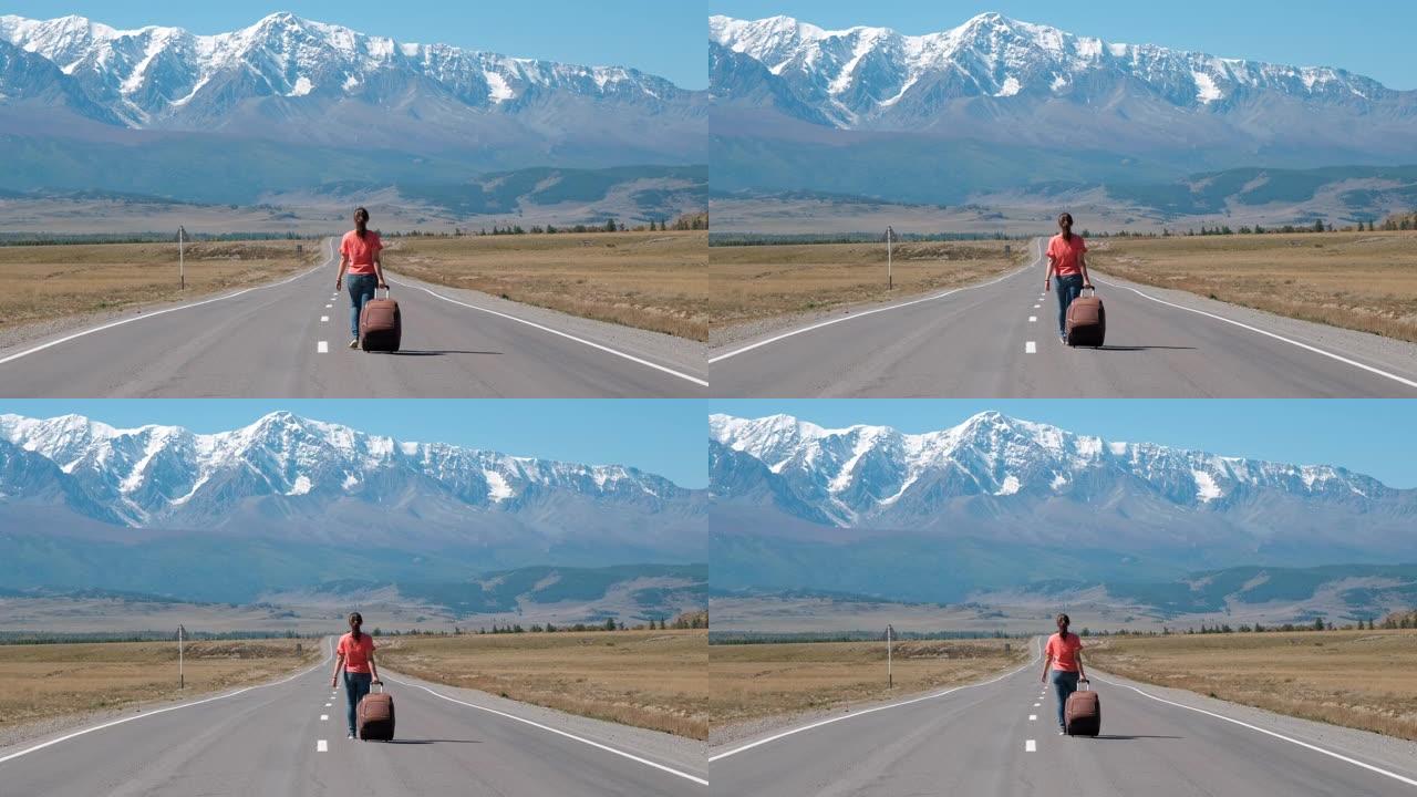 女人带着手提箱在山路上旅行