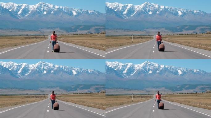 女人带着手提箱在山路上旅行