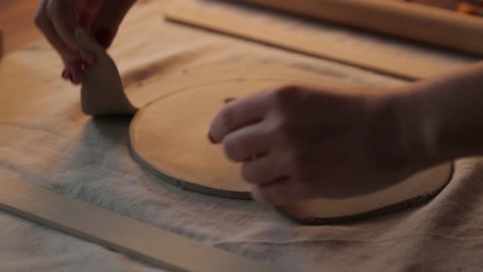 在车间制作粘土板的过程。手工陶瓷制作的装饰餐具特写。