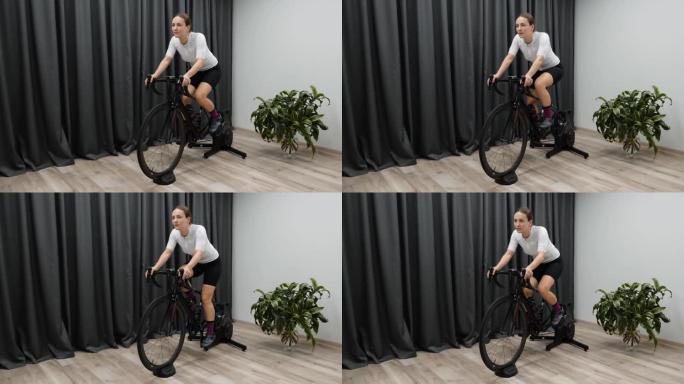 在智能教练的室内骑自行车，为比赛做准备，在固定自行车上进行硬踩踏有氧运动。自行车概念。
