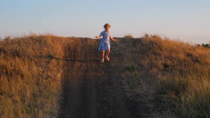 可爱的小女孩穿着蓝色夏装爬上山坡。在野草乡村景观中奔跑的孩子。家人在新鲜空气中行走。当地徒步旅行概念
