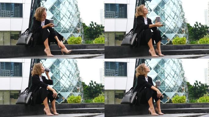 女商人穿着高跟鞋后在户外喝咖啡休息，感到疼痛