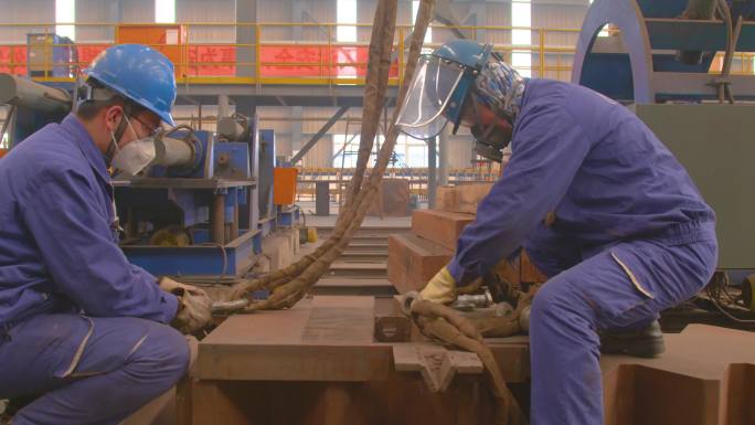 在机器上工作的人 在工厂工作的一群人 两个男人正在处理一块金属