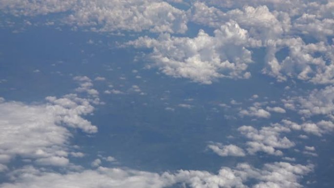 4K。放大通过飞机窗口看到的云层。旅行