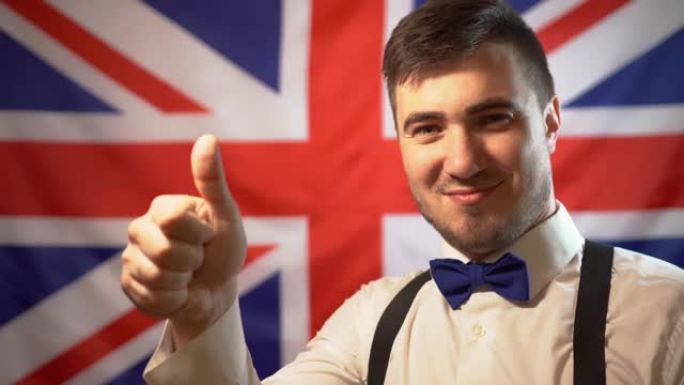 一个快乐的英国人的肖像，他在英国国旗的背景上竖起大拇指。