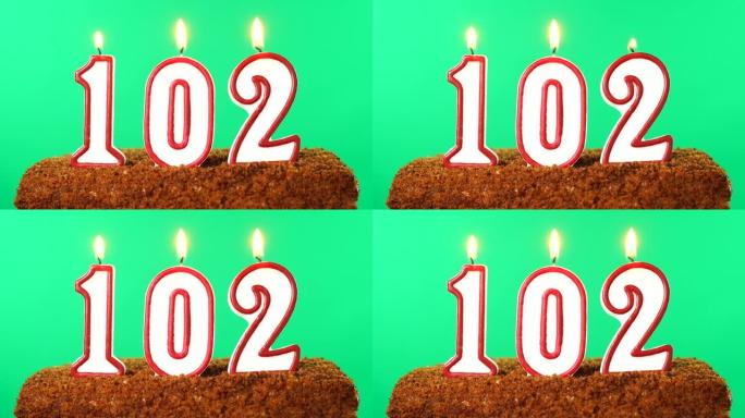 蛋糕与数字102点燃的蜡烛。色度键。绿屏。隔离