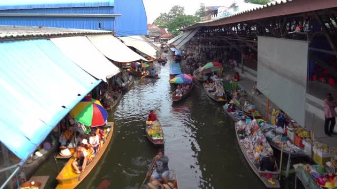 在泰国Ratchaburi区的Damnoen Saduak浮动市场，当地人在船上出售水果，食物和纪念