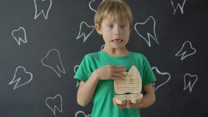 小男孩展示了一个用来装乳牙的木盒子。儿童牙齿改变的概念
