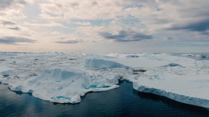 格陵兰岛伊卢利萨特地区白冰岸、浮冰和冰山上缓慢而雄伟的无人机鸟瞰图
