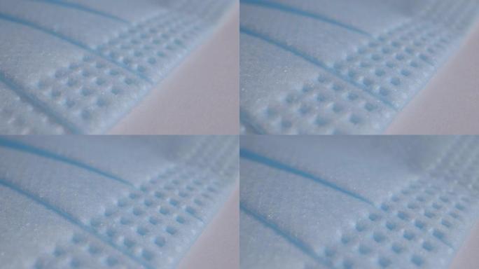 极端宏观特写移动镜头显示保护性面膜的纹理，以防止感冒和流感季节的细菌传播