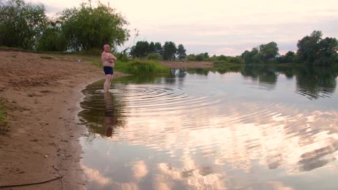 湖上的一个年轻人进入凉水。