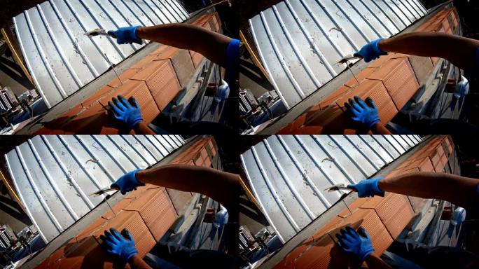 一名男子在建筑屋顶施工中钉钉子的特写镜头