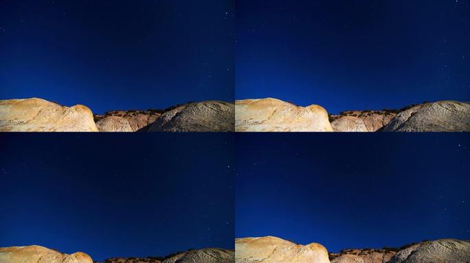 夜空中星星在沙漠山脉上的运动。