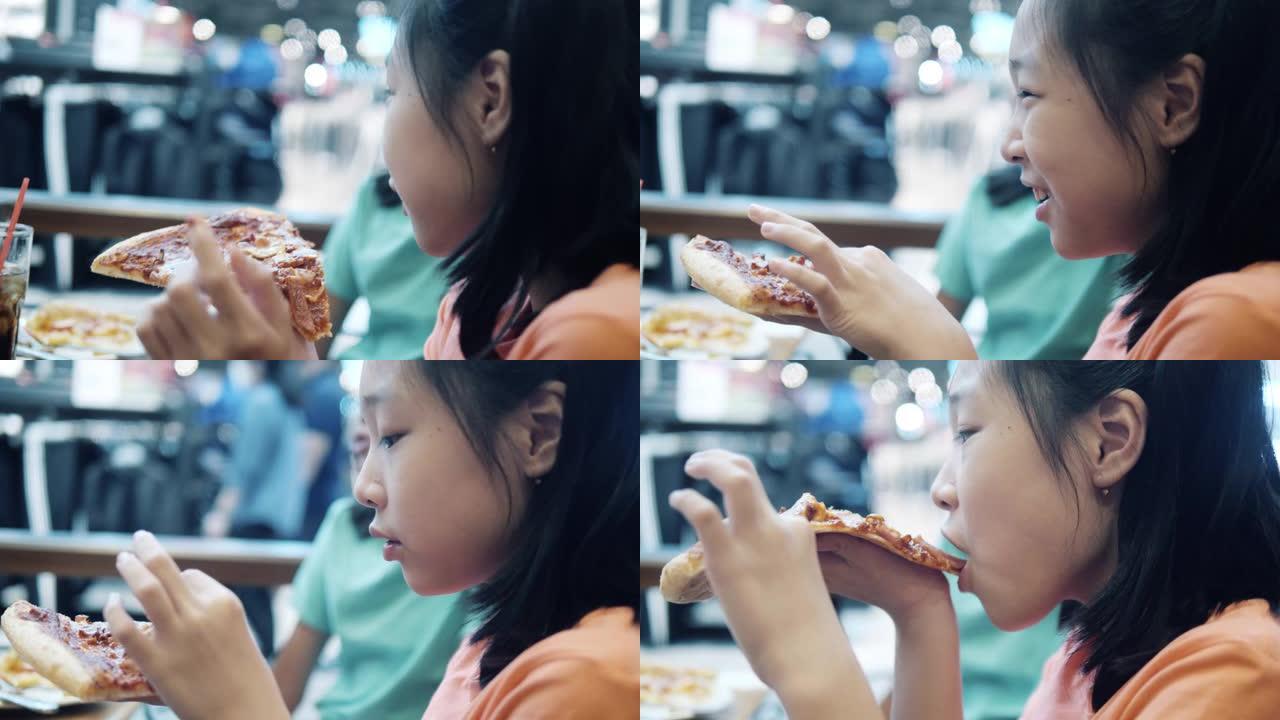 快乐的亚洲儿童在餐厅一起吃披萨和意大利食物。
