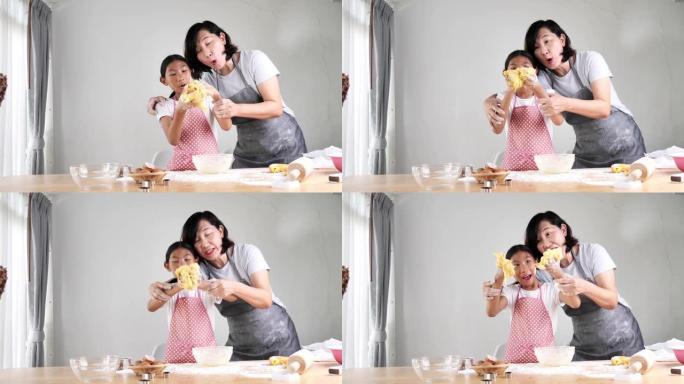 快乐的亚洲女孩在家帮助母亲一起制作面包或比萨饼的面团，生活方式的概念。