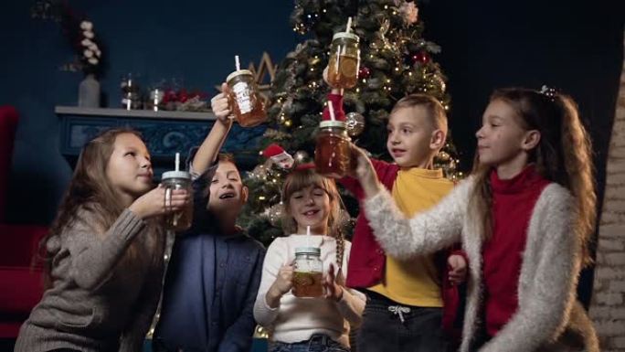 可爱的五个孩子在舒适的房间的圣诞树背景上喝彩