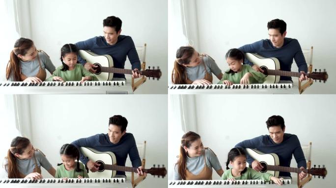快乐的亚洲小女儿和妈妈一起弹钢琴，爸爸在家弹吉他，妈妈教女儿弹钢琴，他们弹唱歌曲。他们玩得很开心。
