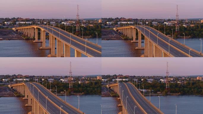 日落前的傍晚，在新泽西州拉里坦河上的胜利桥上鸟瞰图，背景是纽约市曼哈顿的遥远景色。平移摄像机运动的视