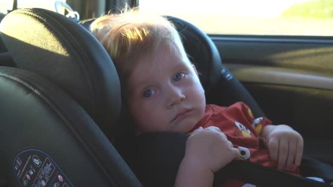 可爱的孩子坐在汽车安全座椅后座