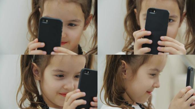 剪短的视频，小辫子的可爱小女孩戴着项链和头套，拿着黑色手机，拍照。