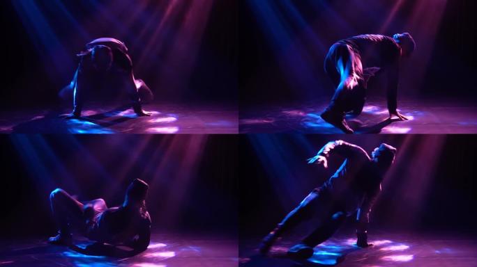 专业霹雳舞和嘻哈舞者的轮廓在聚光灯下在地板上旋转。特写。慢动作