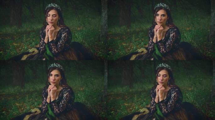 穿着黑色连衣裙的美女哥特式女王坐在黑暗的森林里，很悲伤。